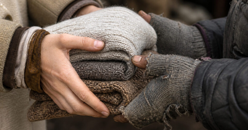 Donación de abrigo en Córdoba: manos compartiendo ropa de invierno para ayudar